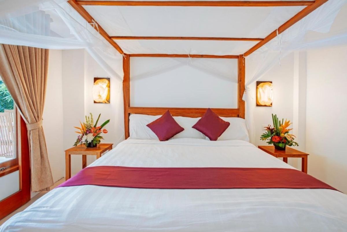 Luxurious Bali villa with infinity pool, tropical garden, wooden lounge chairs, and outdoor dining area. - Bali Villas