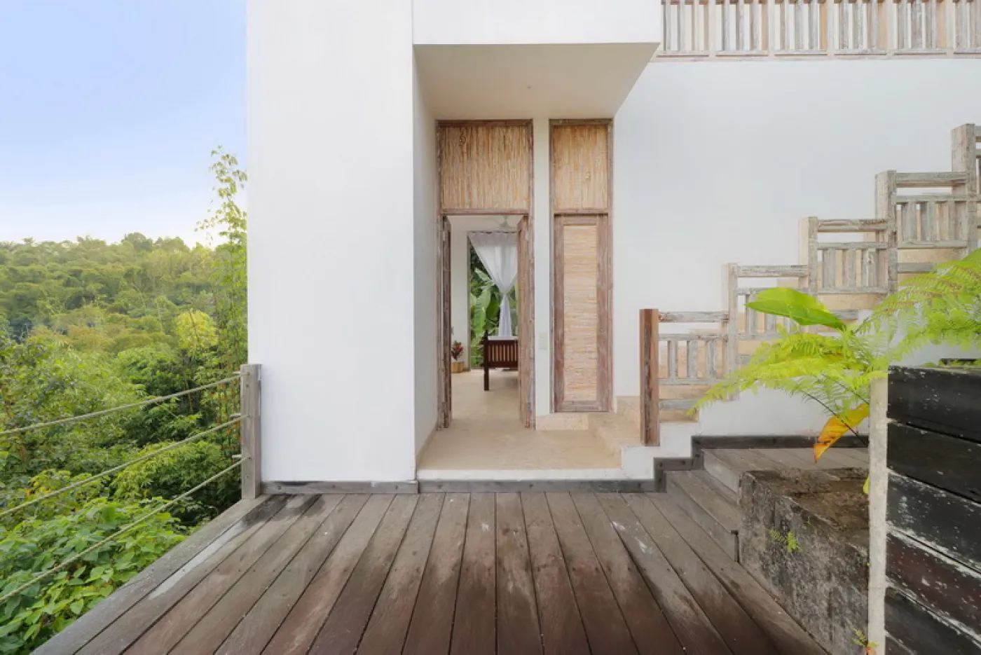 Modern luxury bathroom featuring a frosted glass block window, wooden accent wall with rain showerhead, and fresh flowers on a side table. - Bali Villas