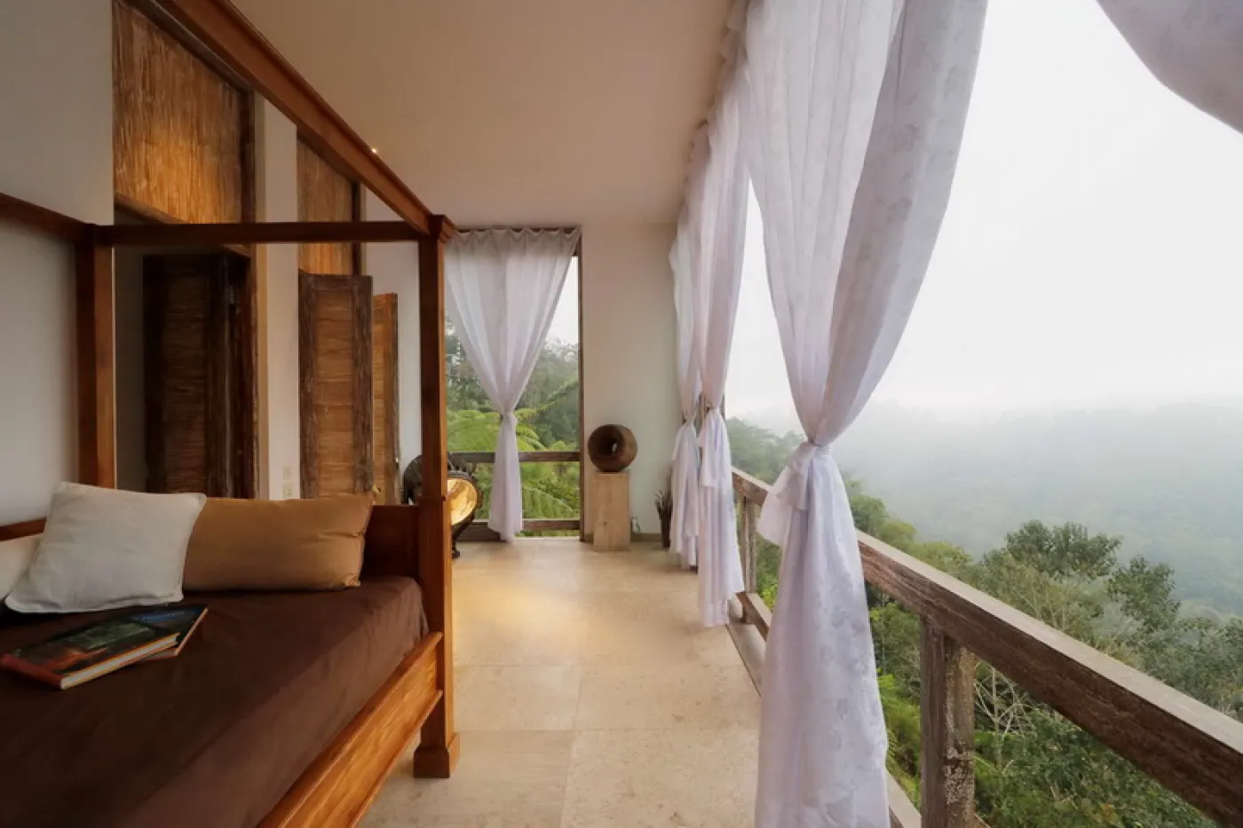 Modern luxury bathroom featuring a frosted glass block window, wooden accent wall with rain showerhead, and fresh flowers on a side table. - Bali Villas