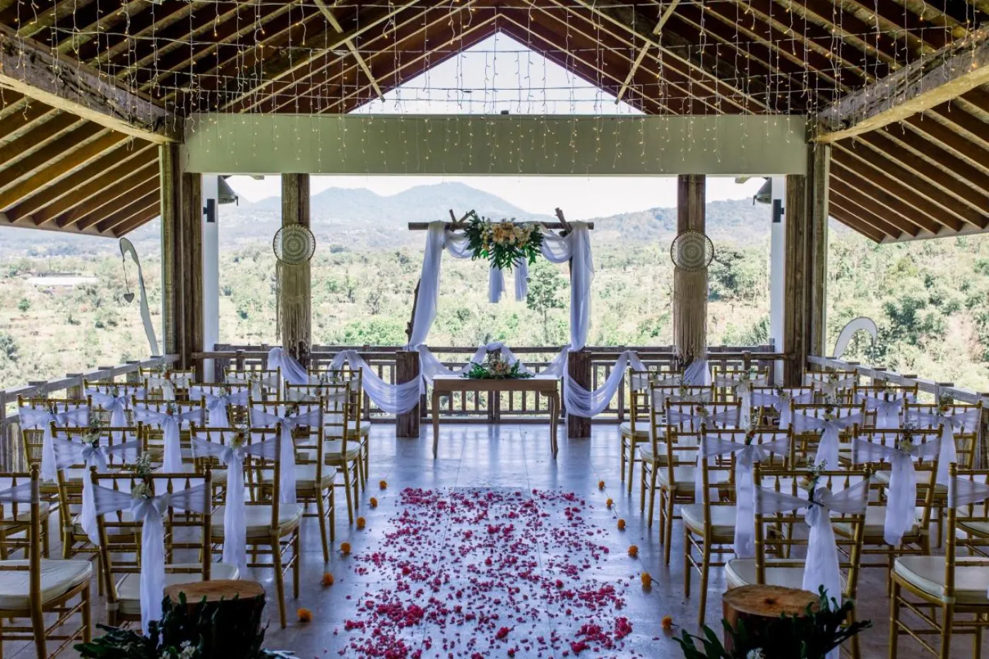 Modern luxury bathroom featuring a frosted glass block window, wooden accent wall with rain showerhead, and fresh flowers on a side table. - Bali Villas