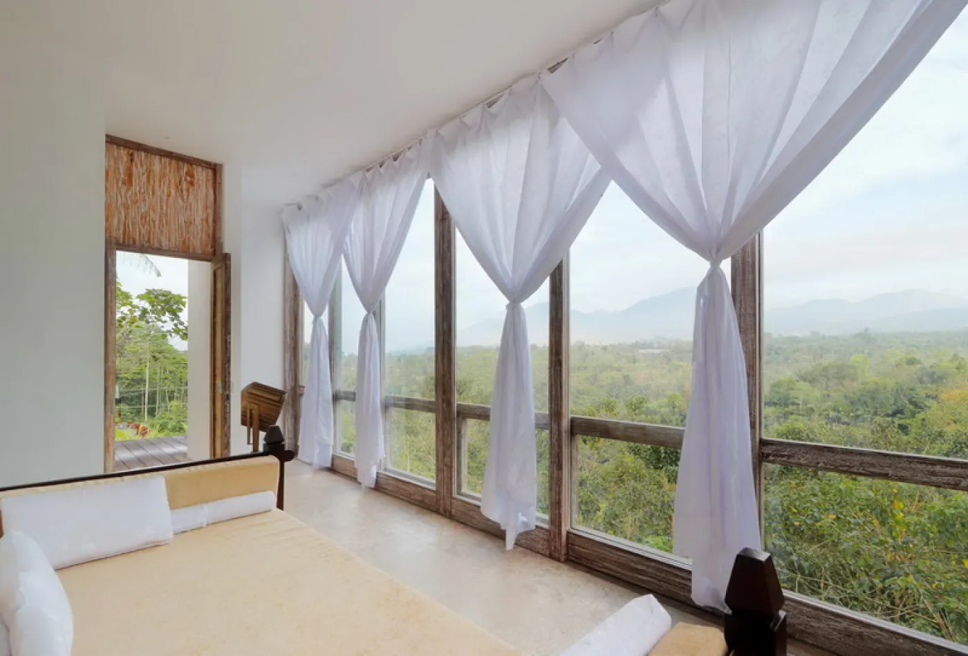 Modern luxury bathroom featuring a frosted glass block window, wooden accent wall with rain showerhead, and fresh flowers on a side table. - Bali Villas