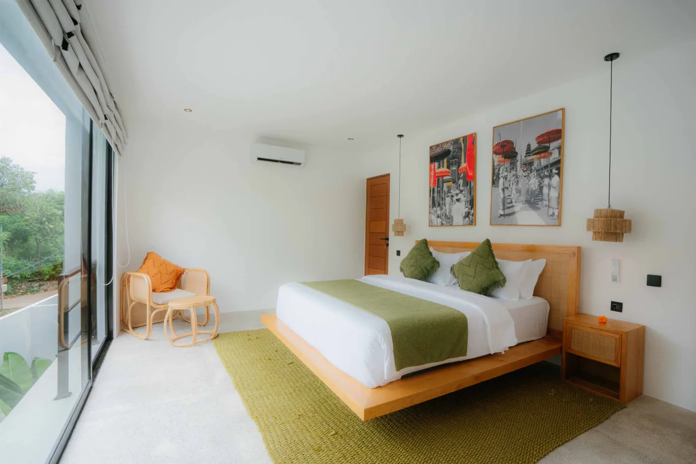 Modern minimalist bathroom interior featuring a walk-in shower, concrete vanity with sink and mirror, rattan pendant lights, and potted pampas grass. - Bali Villas