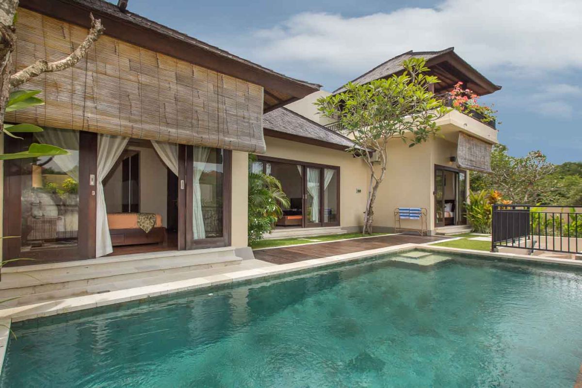 Luxurious Balinese villa with private infinity pool, tropical plants, and open-air living spaces. - Bali Villas