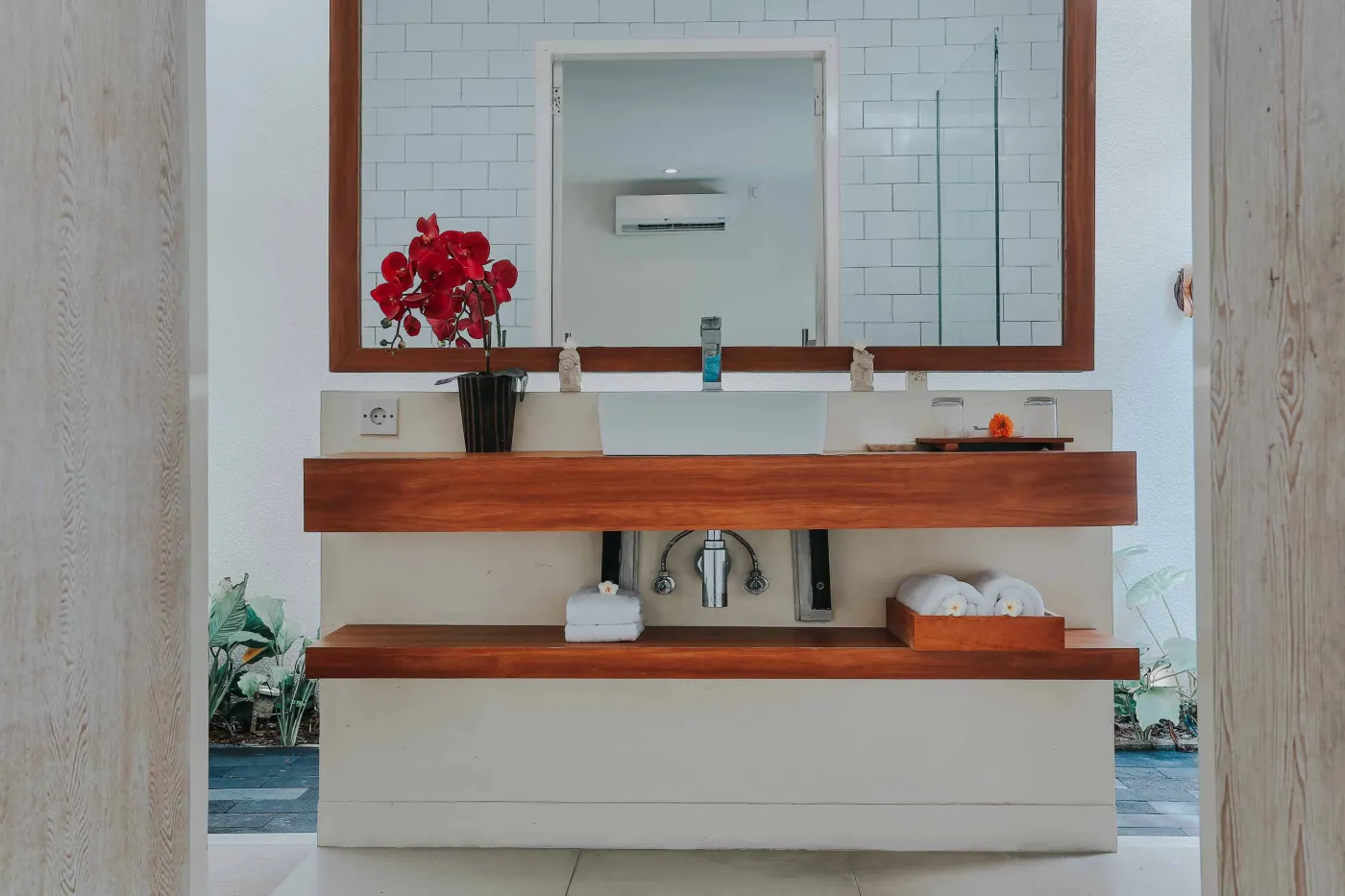 Serene private infinity pool in a modern Balinese villa courtyard, with white lounge chairs, tiled table, and tropical stone decor. - Bali Villas
