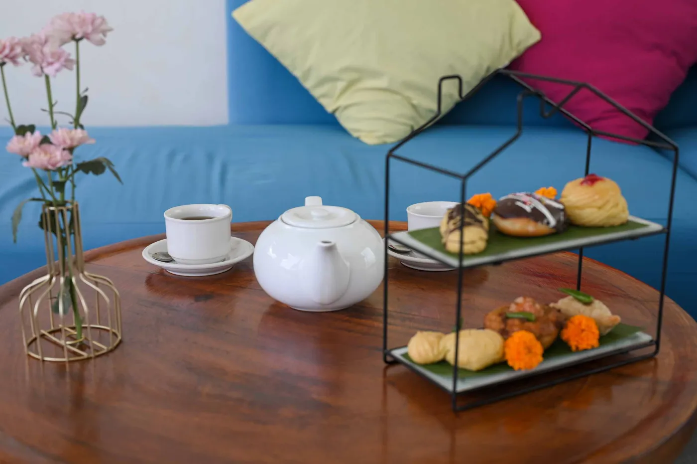 Luxurious Bali villa bedroom with king bed, wooden accents, wall mirror, and open balcony doors overlooking infinity pool and tropical palms. - Bali Villas