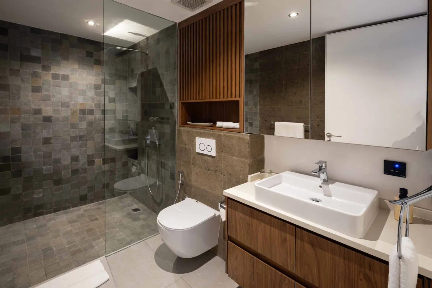 Serene private infinity pool in a tropical Bali villa, surrounded by lush palms, bean bag seating, and modern stone walls. - Bali Villas