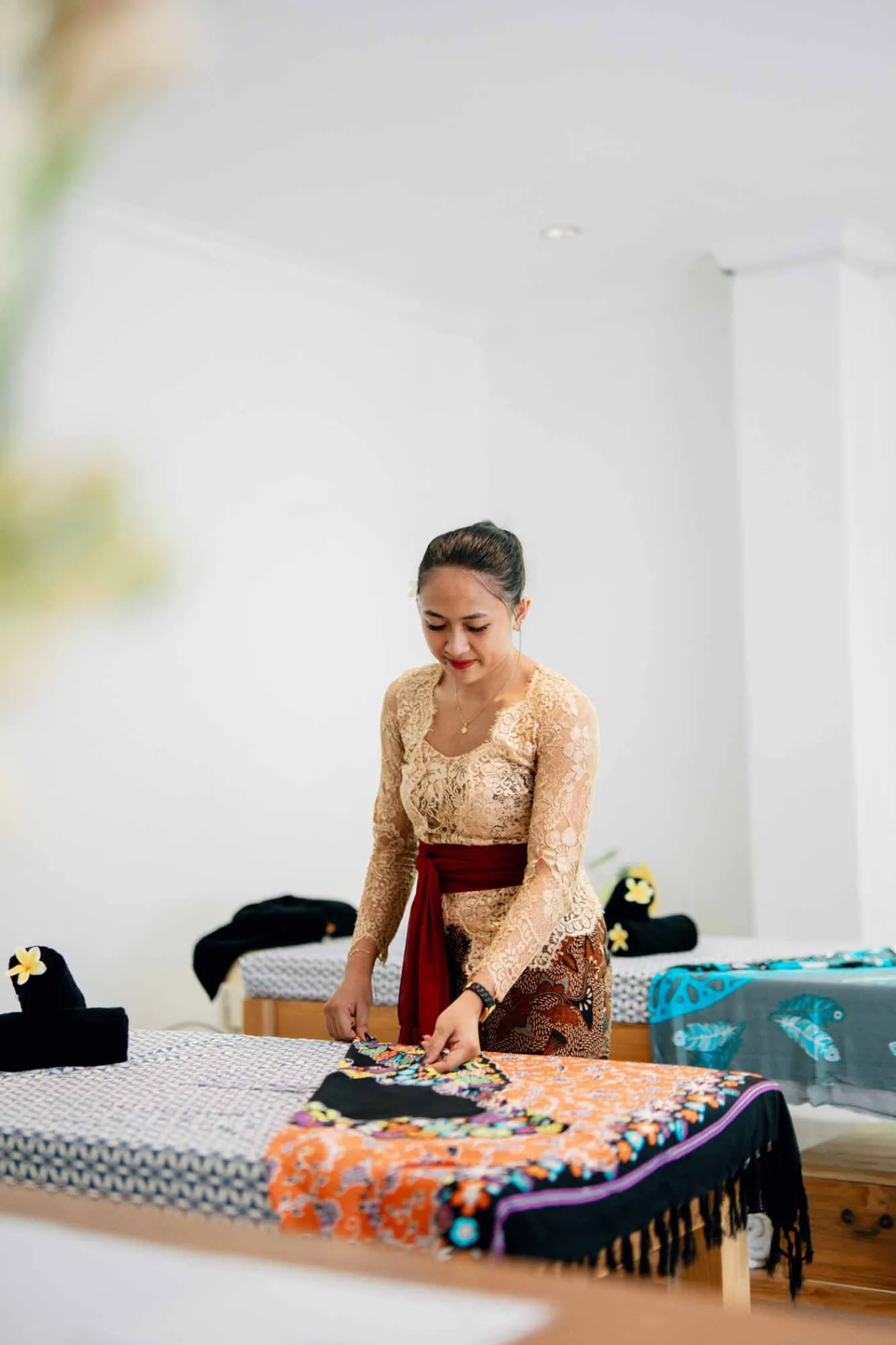 Modern white bathroom featuring a toilet, glass shower enclosure, hanging towel, and tiled walls. - Bali Villas