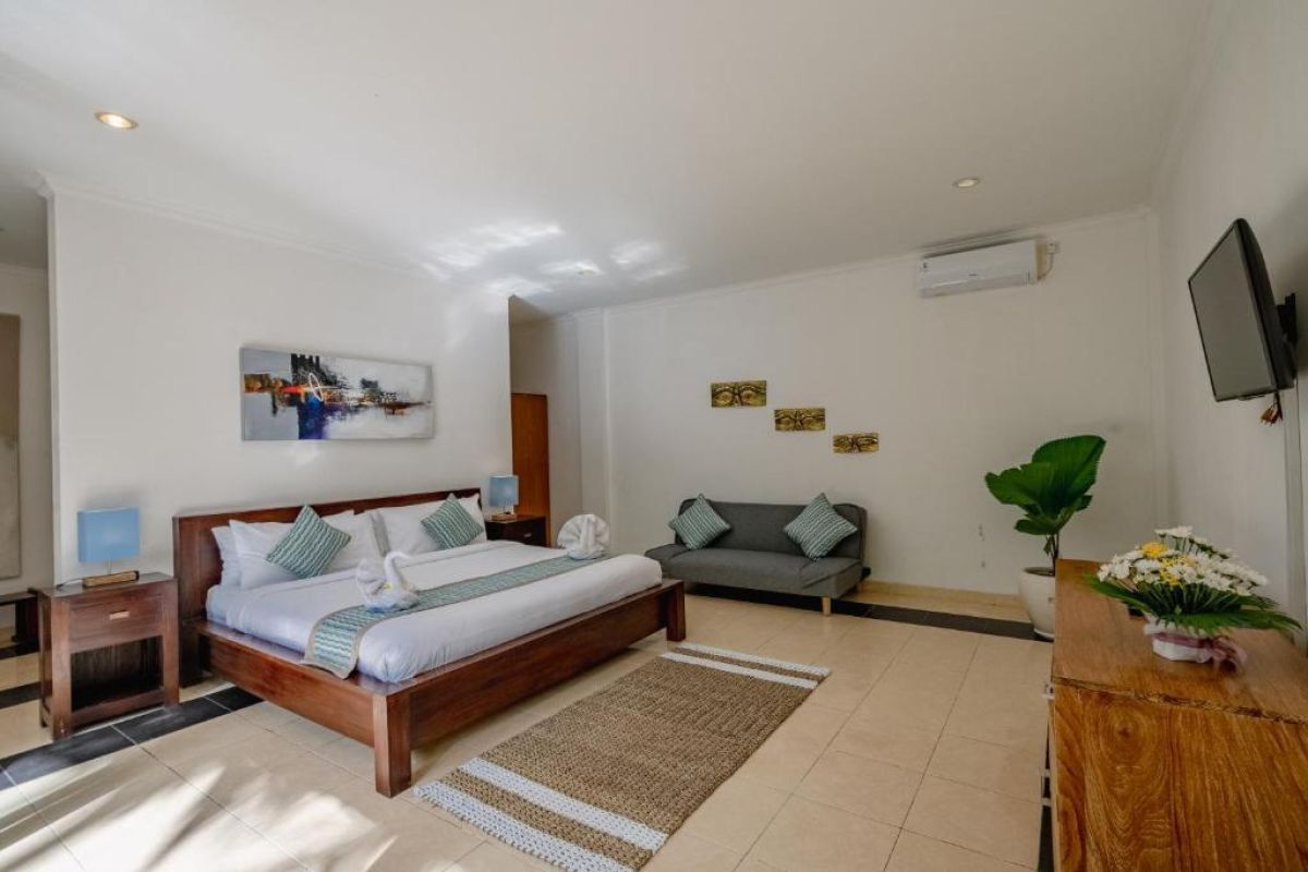 Modern white kitchen featuring wooden island, black granite counters, pull-out faucet sink, and woven pendant light. - Bali Villas