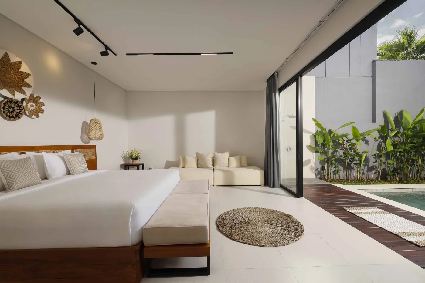 Modern open-plan kitchen and dining area with wooden furniture, tropical plants, and Balinese-style decor. - Bali Villas