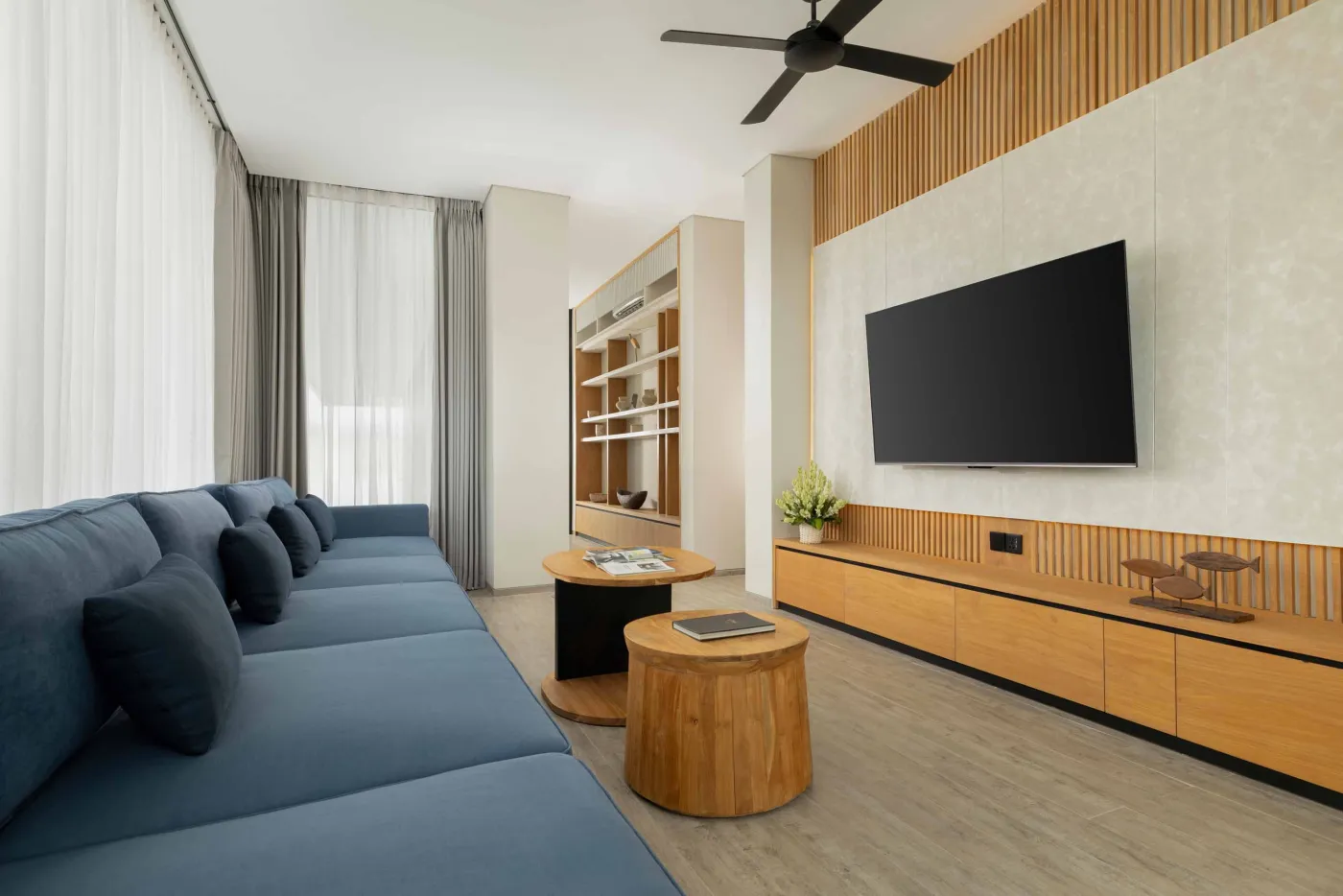 Modern luxury bathroom with freestanding bathtub, walk-in rain shower, wooden accents, and bedroom view. - Bali Villas