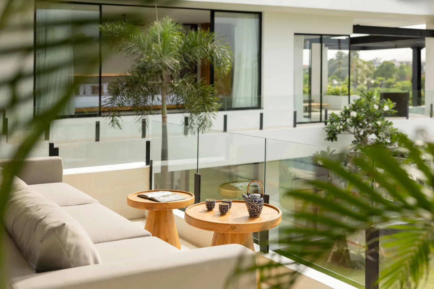 Modern luxury bathroom with freestanding bathtub, walk-in rain shower, wooden accents, and bedroom view. - Bali Villas