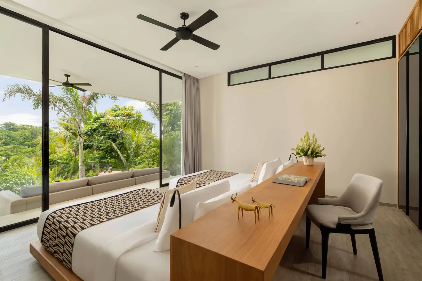 Modern luxury bathroom with freestanding bathtub, walk-in rain shower, wooden accents, and bedroom view. - Bali Villas