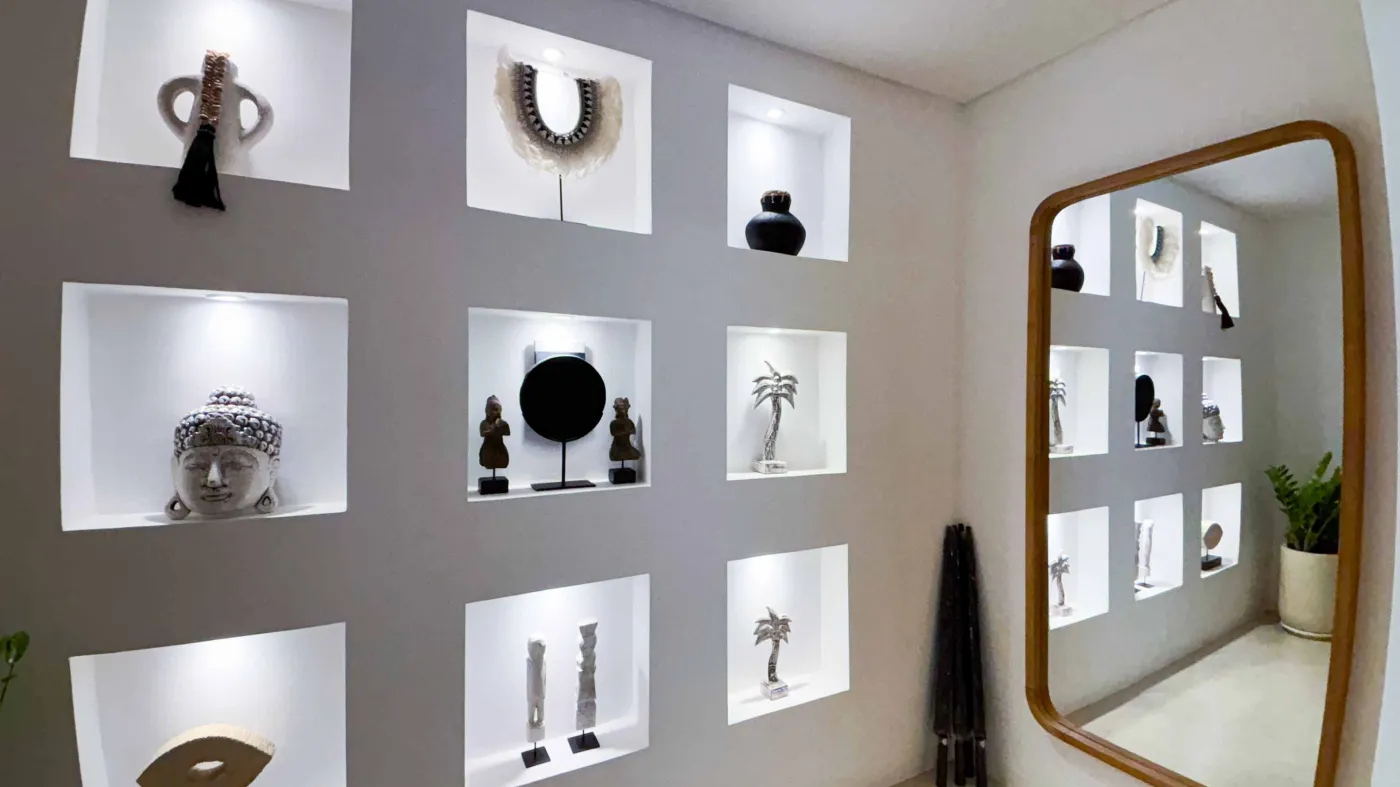 Modern minimalist bathroom with white stone sink, black fixtures, glass shower enclosure, and folded towels on counter. - Bali Villas