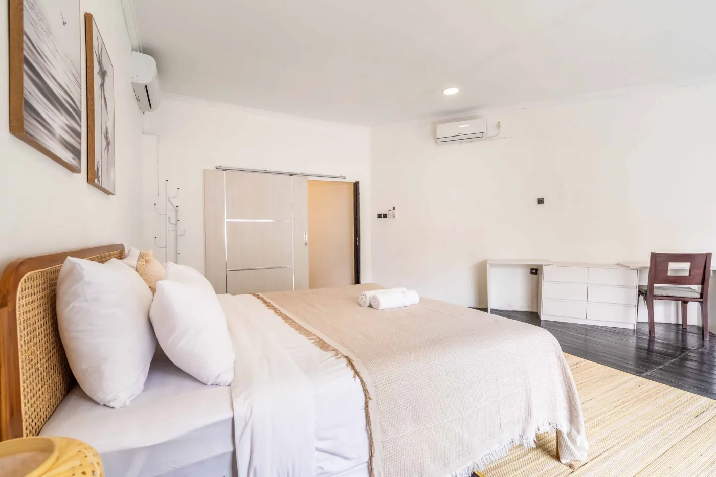 Modern white-tiled bathroom with glass shower enclosure, sink, and toilet. - Bali Villas