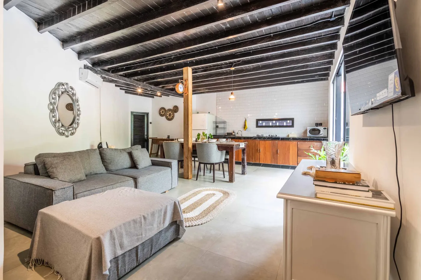 Modern white-tiled bathroom with glass shower enclosure, sink, and toilet. - Bali Villas