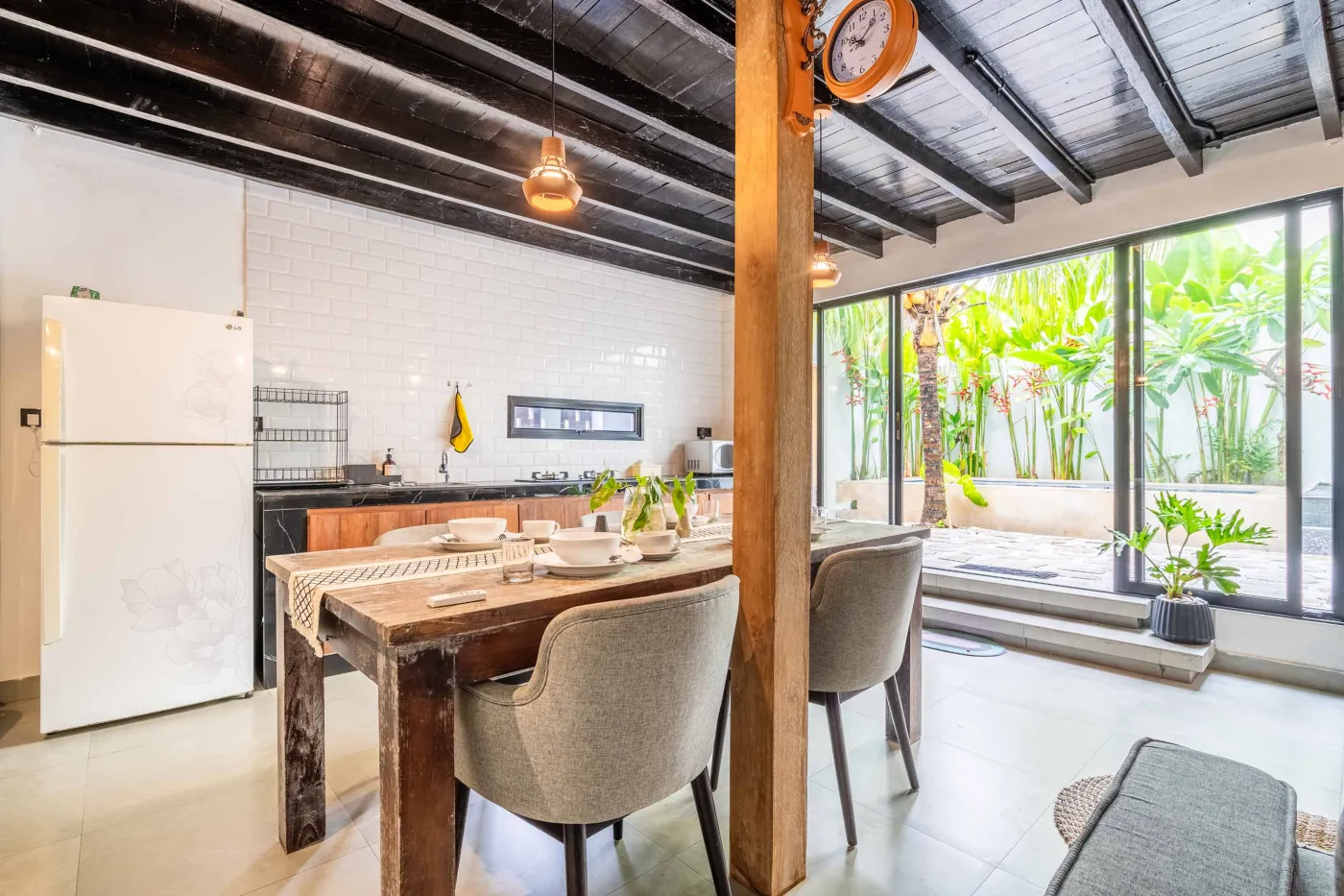Modern white-tiled bathroom with glass shower enclosure, sink, and toilet. - Bali Villas