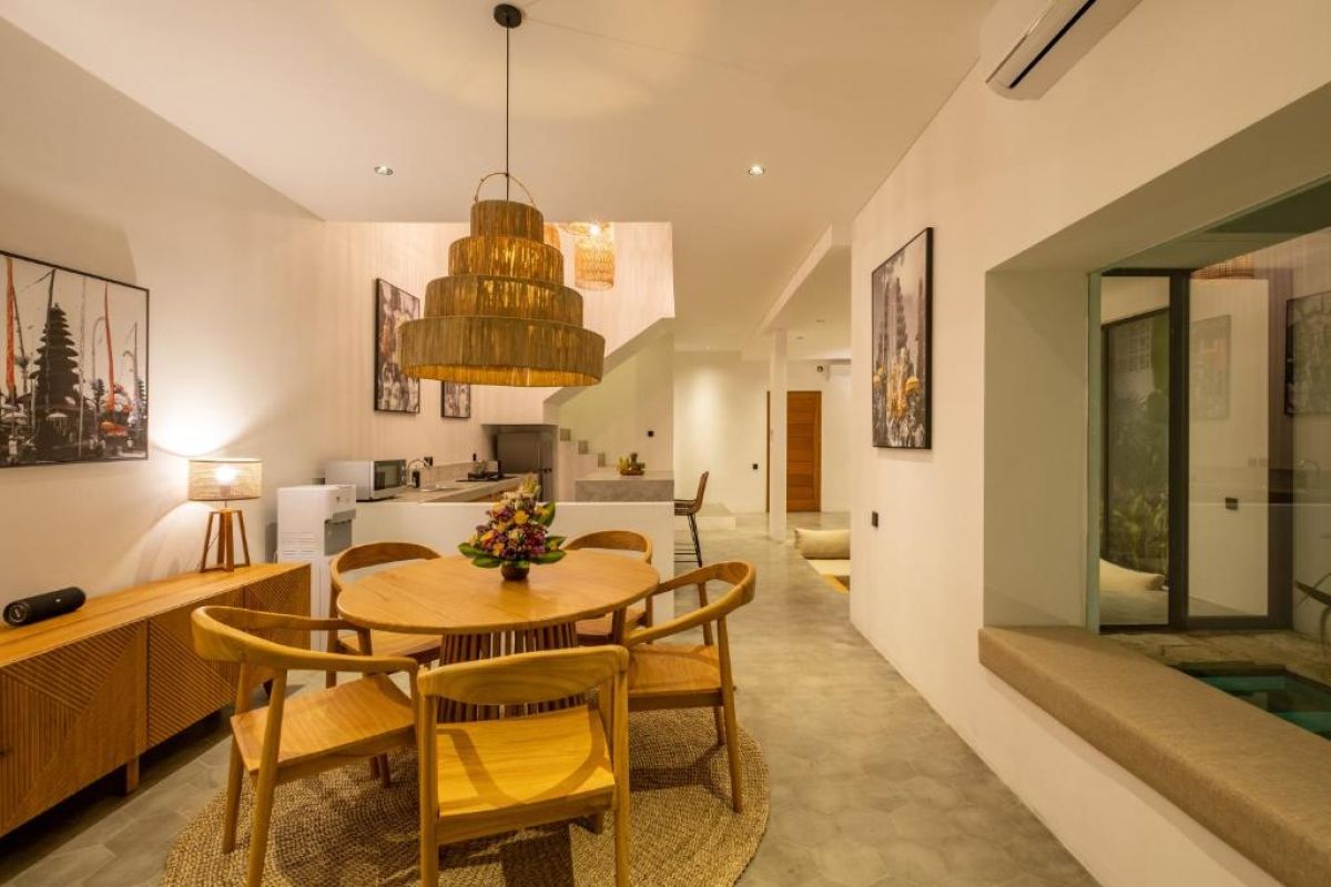 Modern tropical villa plunge pool with lounge daybed, parasol, and lush greenery. - Bali Villas