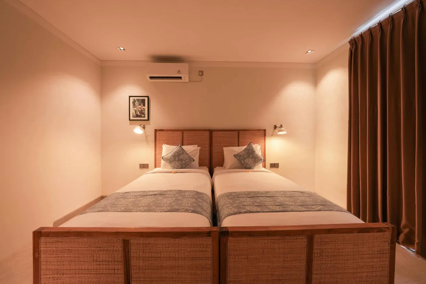 Modern wooden kitchen with stainless steel sink, refrigerator, microwave, cooktop, and warm LED lighting. - Bali Villas