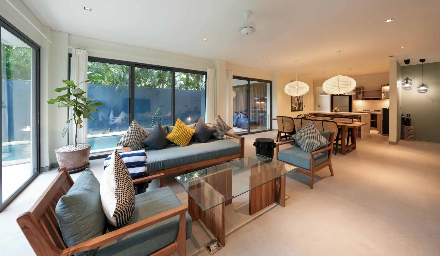 Modern wooden kitchen with stainless steel sink, refrigerator, microwave, cooktop, and warm LED lighting. - Bali Villas