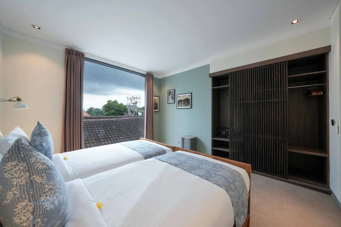 Modern wooden kitchen with stainless steel sink, refrigerator, microwave, cooktop, and warm LED lighting. - Bali Villas