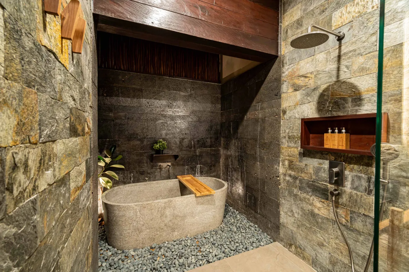 Luxurious Balinese bedroom with king bed, bamboo ceiling, lush plants, and sliding doors to private pool. - Bali Villas