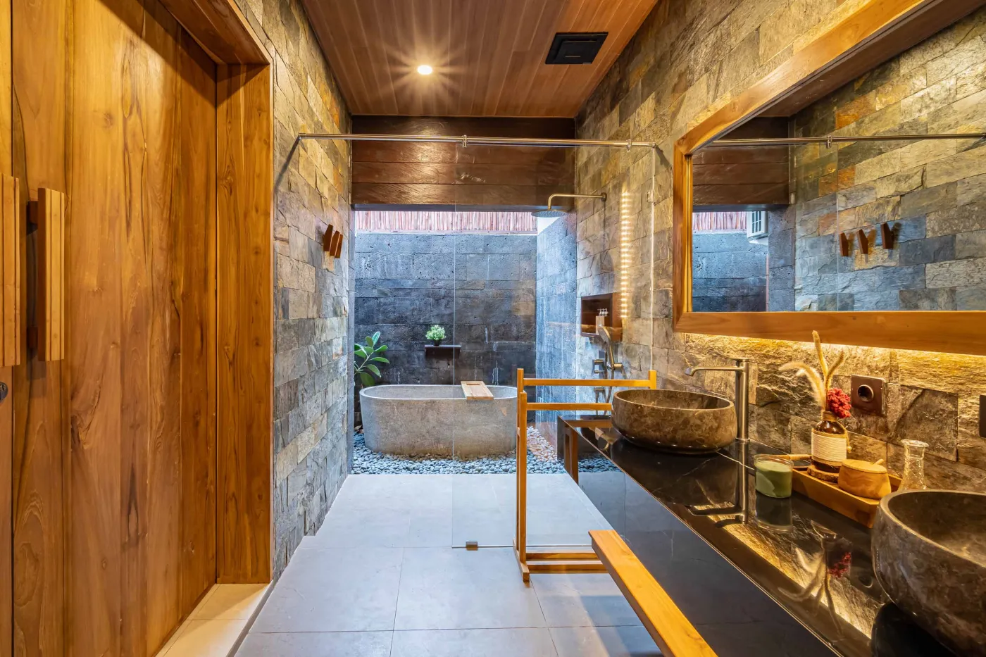 Luxurious Balinese bedroom with king bed, bamboo ceiling, lush plants, and sliding doors to private pool. - Bali Villas