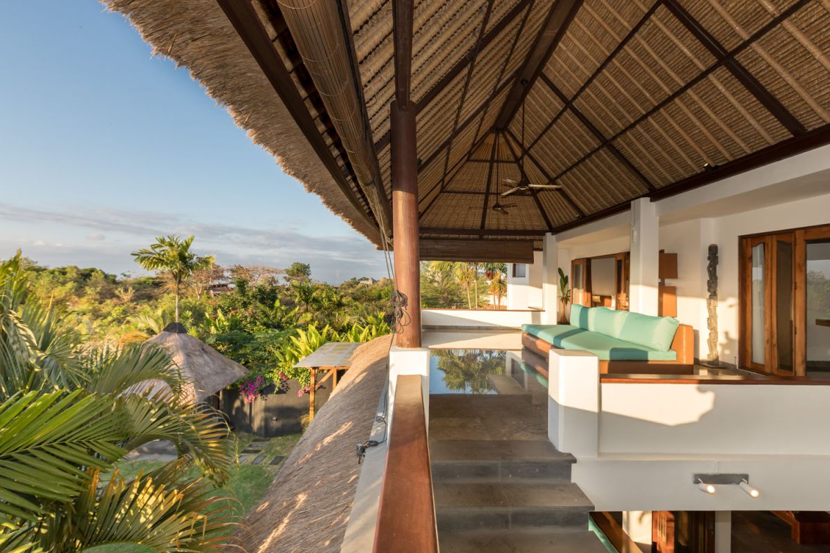 Spacious Balinese-style bathroom with tropical plants, open glass shower, white vanity, and skylight. - Bali Villas