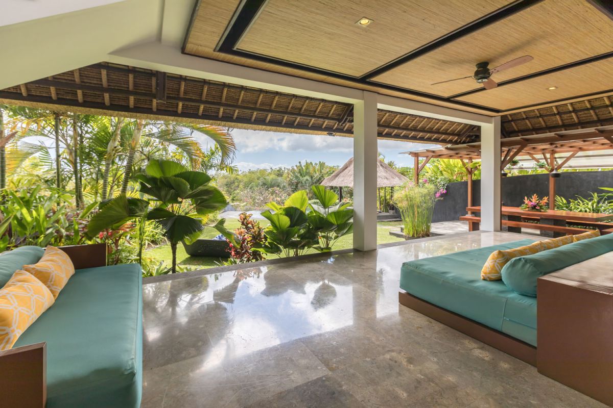 Spacious Balinese-style bathroom with tropical plants, open glass shower, white vanity, and skylight. - Bali Villas