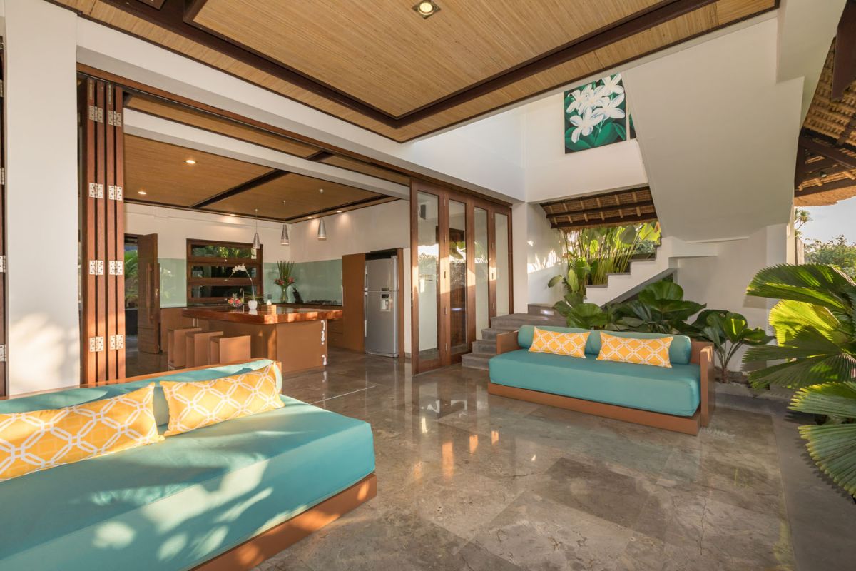 Spacious Balinese-style bathroom with tropical plants, open glass shower, white vanity, and skylight. - Bali Villas