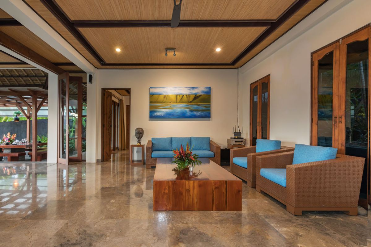 Spacious Balinese-style bathroom with tropical plants, open glass shower, white vanity, and skylight. - Bali Villas
