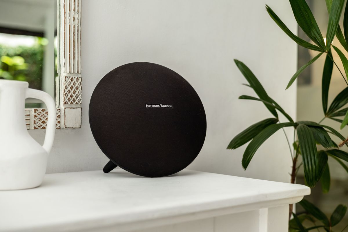 Modern white kitchen bar with concrete countertop, wooden stools, and lush tropical greenery outside arched windows. - Bali Villas