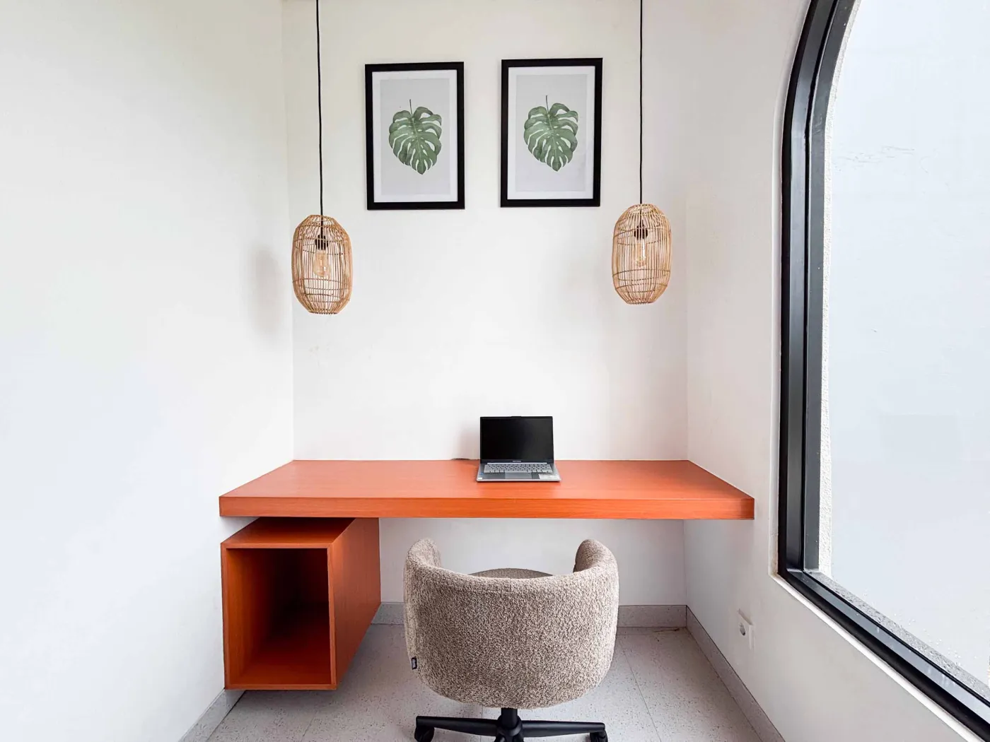Modern tropical villa kitchen and dining area with orange cabinets, wooden ceiling, pendant lights, and outdoor pool view featuring a statue. - Bali Villas