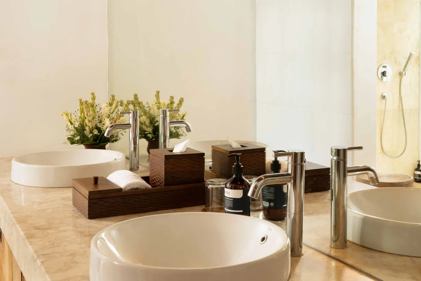 Spacious open-plan living and dining area in a modern tropical villa with exposed wooden beams, white walls, hardwood floors, and large windows. - Bali Villas