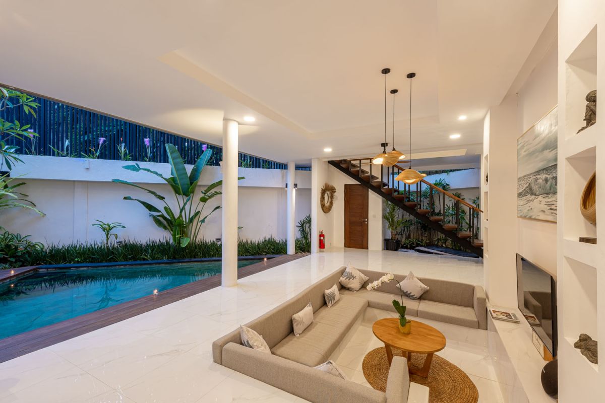 Modern luxury bathroom with freestanding bathtub filled with petals, double vessel sink vanity, glass shower, and tropical accents. - Bali Villas