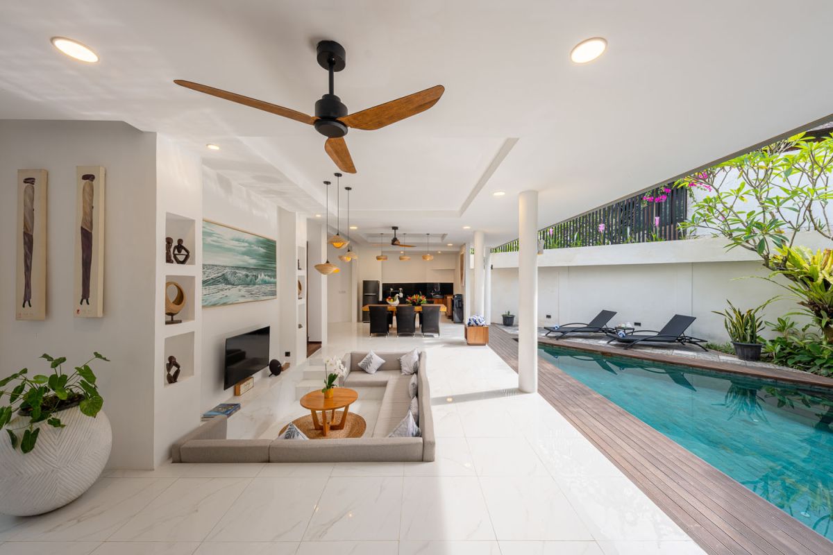 Modern luxury bathroom with freestanding bathtub filled with petals, double vessel sink vanity, glass shower, and tropical accents. - Bali Villas
