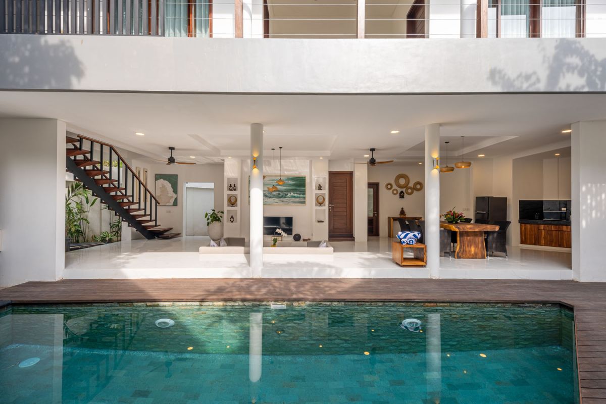 Modern luxury bathroom with freestanding bathtub filled with petals, double vessel sink vanity, glass shower, and tropical accents. - Bali Villas