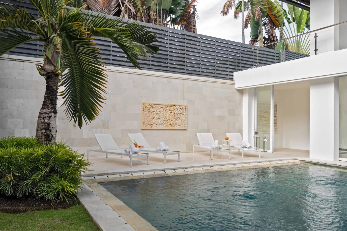 Modern home gym featuring a treadmill, weight bench, pull-up bars, exercise balls, and pink "Lifting" neon sign in a mirrored room. - Bali Villas