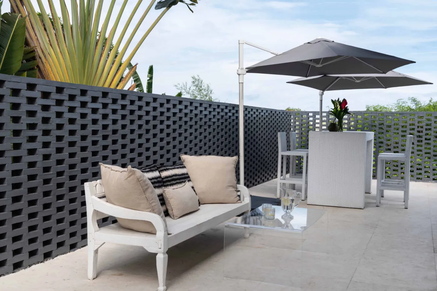 Modern home gym featuring a treadmill, weight bench, pull-up bars, exercise balls, and pink "Lifting" neon sign in a mirrored room. - Bali Villas