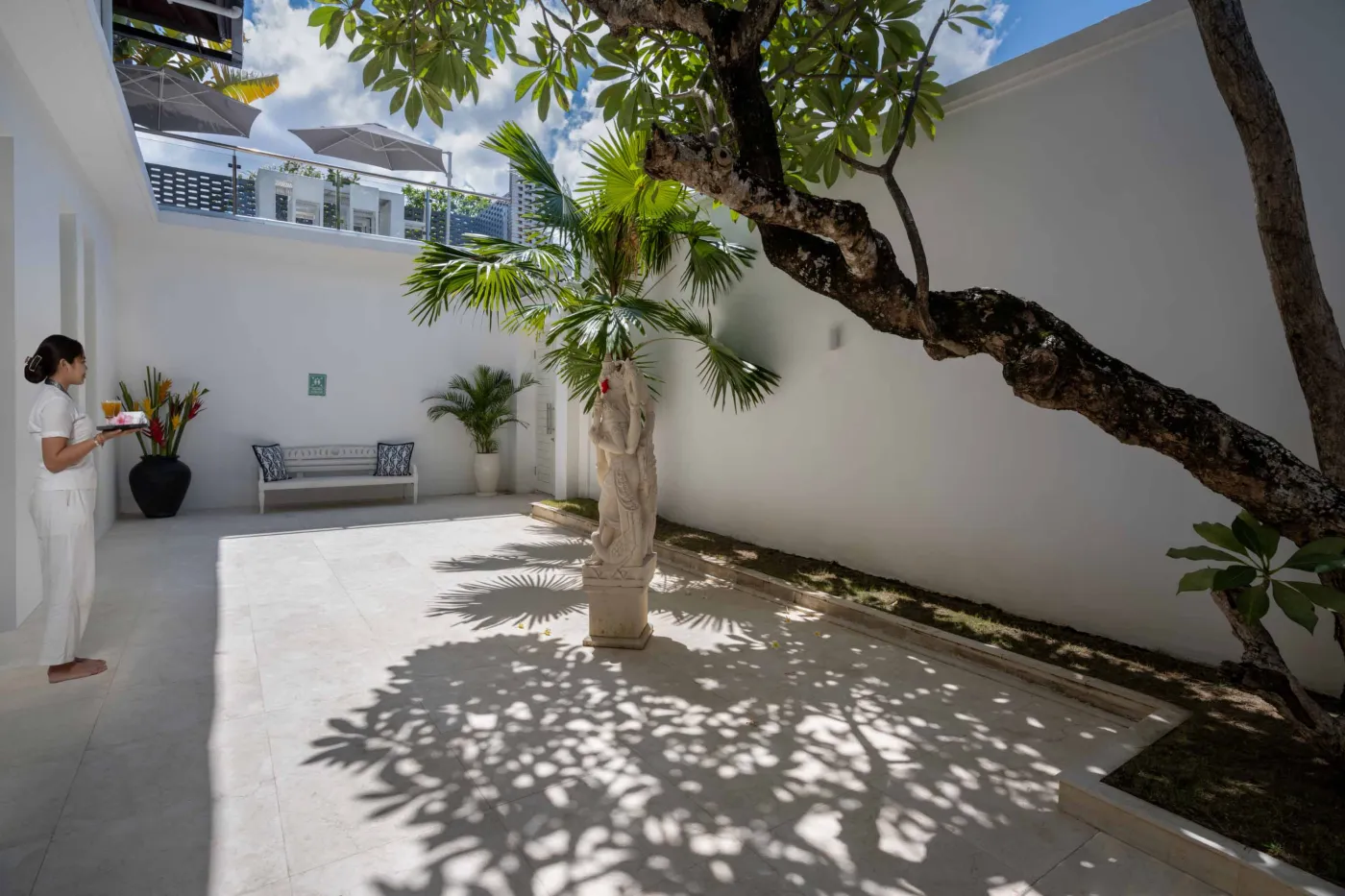 Modern home gym featuring a treadmill, weight bench, pull-up bars, exercise balls, and pink "Lifting" neon sign in a mirrored room. - Bali Villas
