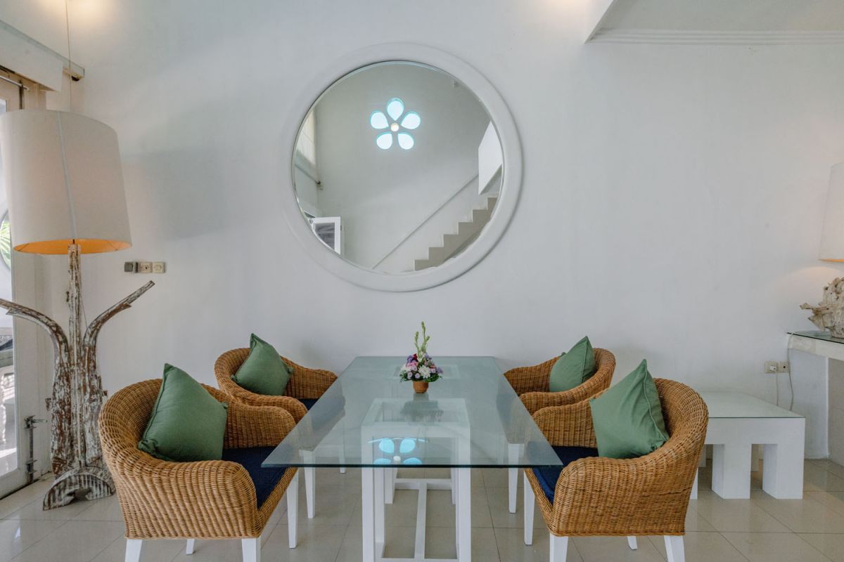 Bright tropical kitchenette with white countertops, fruit platter, louvered cabinets, fridge, and warm lamp lighting. - Bali Villas