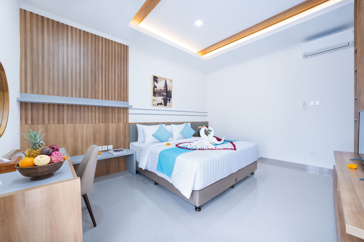 Spacious modern kitchen and dining area with wooden table set for meals, open cabinetry, and sliding glass doors to pool. - Bali Villas