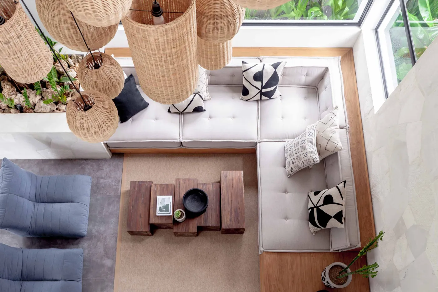 Spacious modern tropical kitchen and dining room with wooden table, rattan chairs, pendant lights, indoor plants, and large windows. - Bali Villas