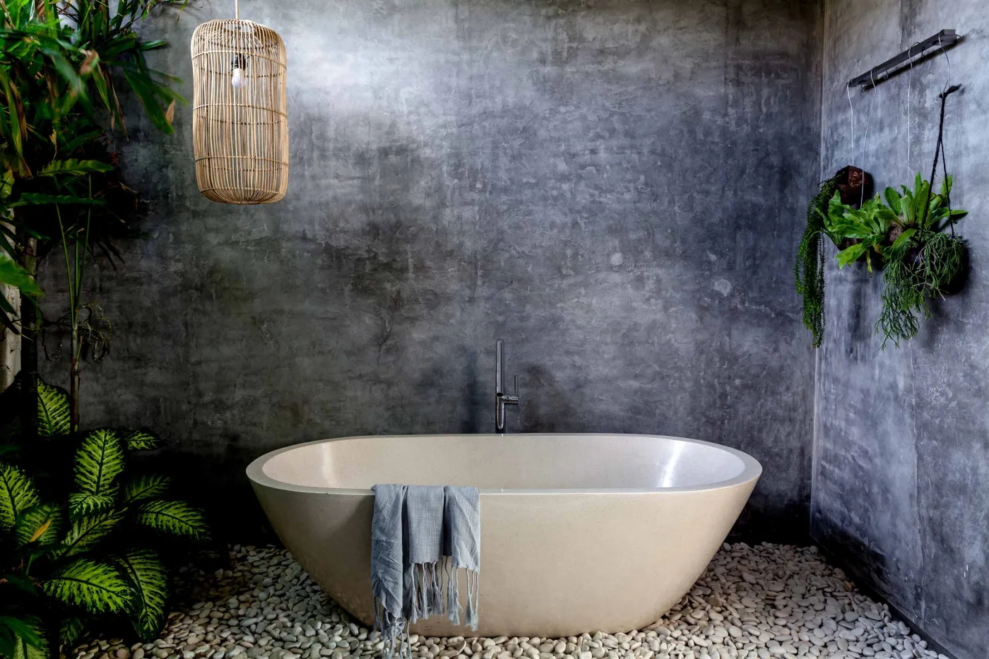 Spacious modern tropical kitchen and dining room with wooden table, rattan chairs, pendant lights, indoor plants, and large windows. - Bali Villas