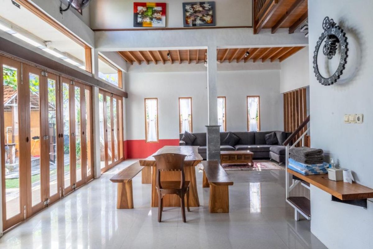 Rustic wooden kitchen with black fridge, gas stove, sink, glass-door cabinets, teal hood, and tiled backsplash. - Bali Villas