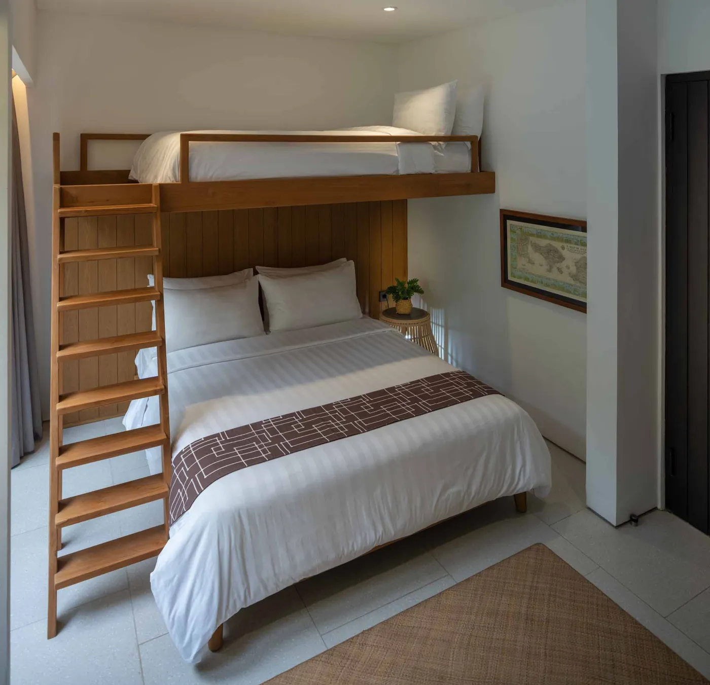 Luxurious open-air Balinese bathroom with freestanding bathtub filled with rose petals, wooden vanity, tropical plants, and geometric tiled floor. - Bali Villas
