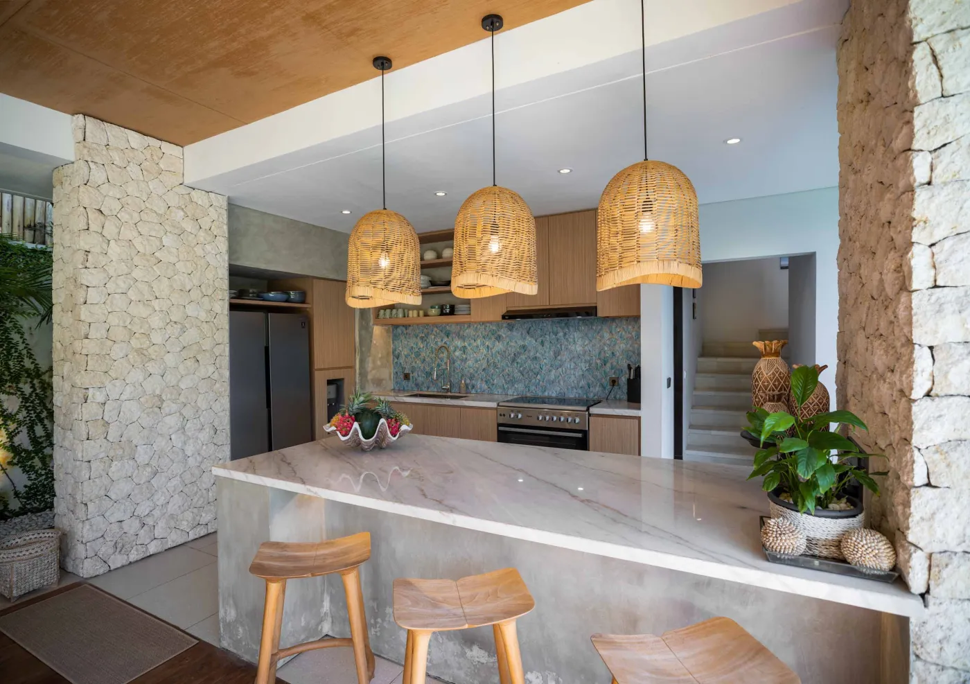 Luxurious open-air Balinese bathroom with freestanding bathtub filled with rose petals, wooden vanity, tropical plants, and geometric tiled floor. - Bali Villas