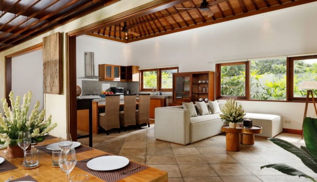 Luxurious tropical Balinese bathroom with stone sink, wooden vanity, open shower, and lush surrounding greenery. - Bali Villas