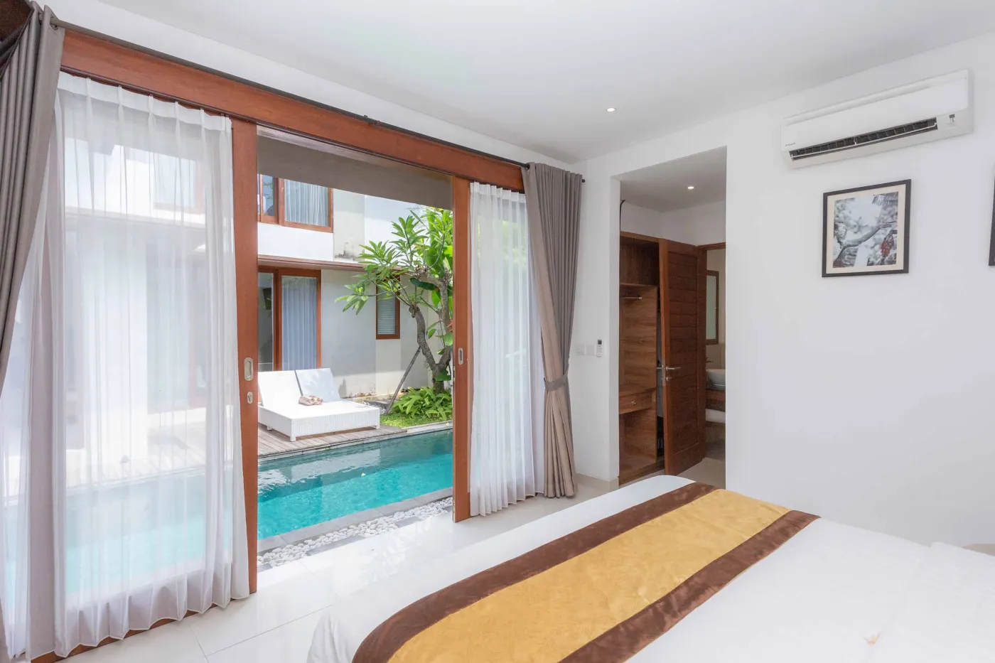 Modern white bathroom featuring a bathtub with shower, toilet, and sink. - Bali Villas