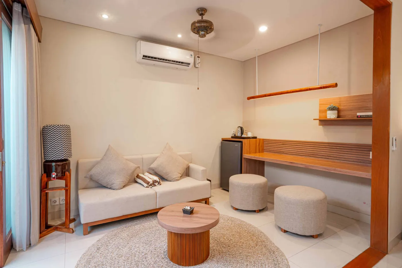 Luxurious Bali pool villa with private plunge pool, red bean bag chairs, and open doors to a rose petal-adorned bedroom. - Bali Villas