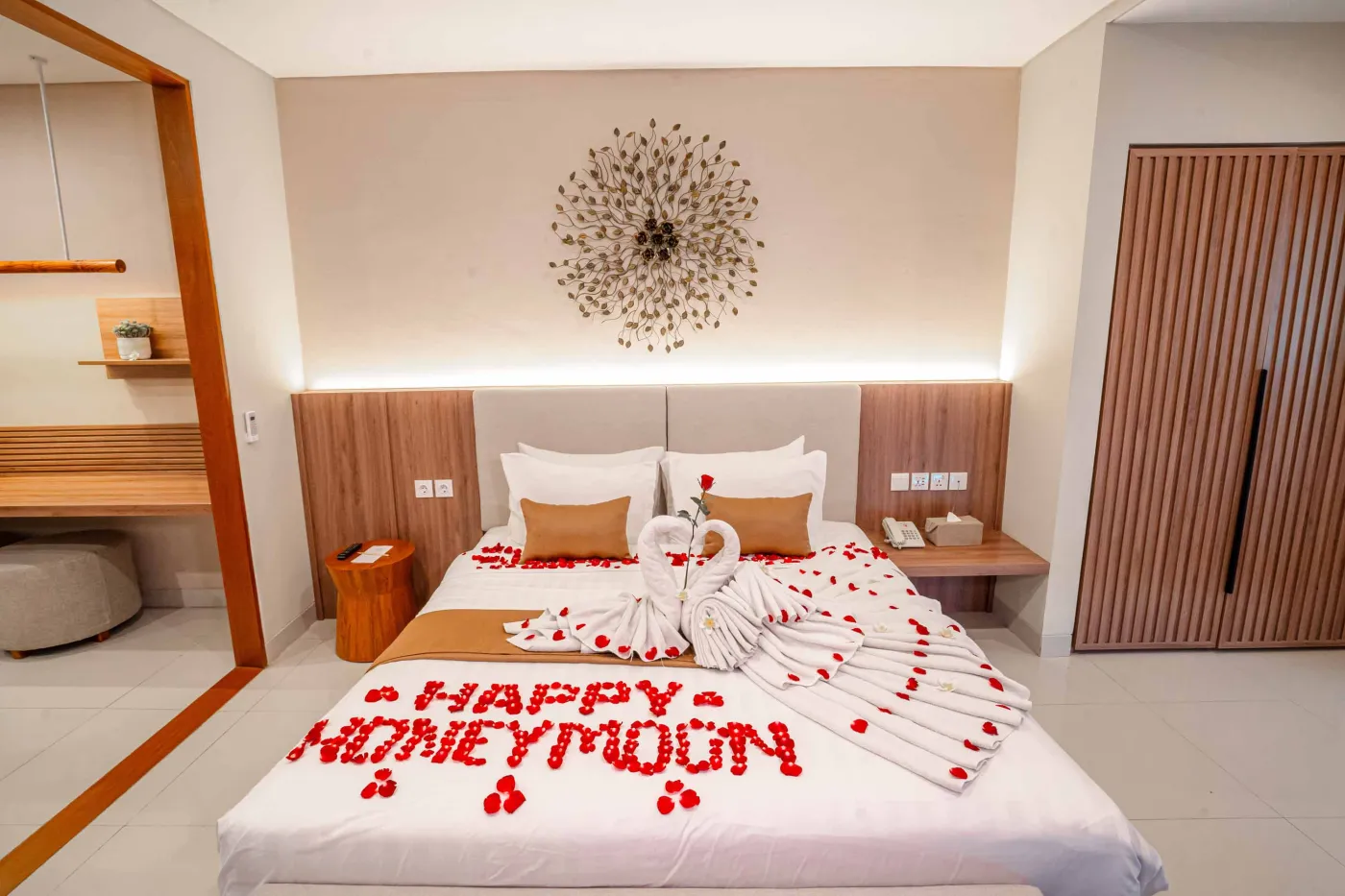 Luxurious Bali pool villa with private plunge pool, red bean bag chairs, and open doors to a rose petal-adorned bedroom. - Bali Villas